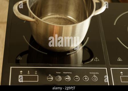 Sartén de inducción negros modernos estufa, horno, encimera o construido en  fogones de vitrocerámica en cocina blanca interior Fotografía de stock -  Alamy