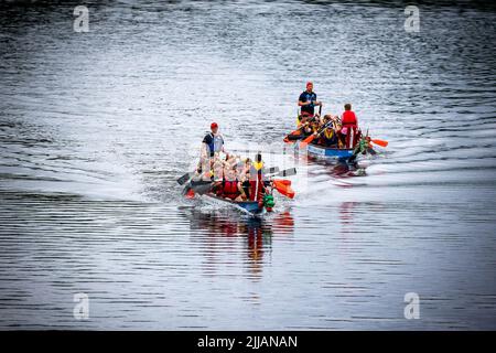 Dos barcos dragón que compiten a lo largo del río Mersey