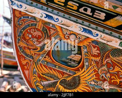 Tailandia: Barcos de pesca Korlae, Saiburi, sur de Tailandia. A lo largo de la costa este de la Tailandia peninsular, desde Ko Samui hacia el sur, los pescadores musulmanes han construido y decorado coloridos barcos de pesca pintados durante cientos de años. Los mejores ejemplos de esta industria, que ahora está en declive, se originan en los astilleros del distrito de Saiburi, provincia de Pattani. Entre los personajes representados en los detallados diseños del casco están el león singha, el pájaro con cuernos gagasura, la serpiente de mar payanak y el pájaro garuda que es tanto el símbolo del reino tailandés como el mítico monte del dios hindú Vishnu.