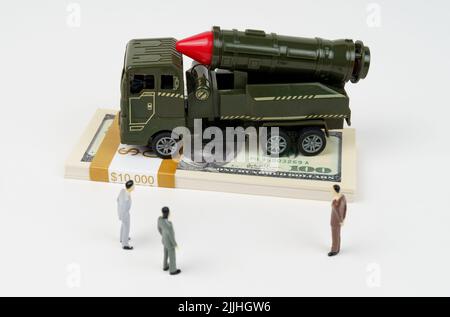 El concepto del presupuesto militar. Sobre el dólar es un vehículo militar de juguete, junto a las cifras de los empresarios. Foto de stock