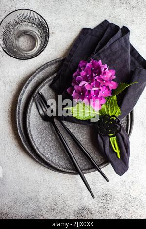 Vajilla negra minimalista sobre mesa de hormigón oscuro Fotografía de stock  - Alamy