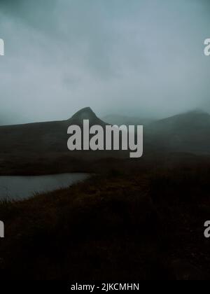 Un paisaje nublado oscuro árido dramático de montaña de baja nube y de loch en las tierras altas del oeste de Escocia Reino Unido - paisaje oscuro de fondo Foto de stock
