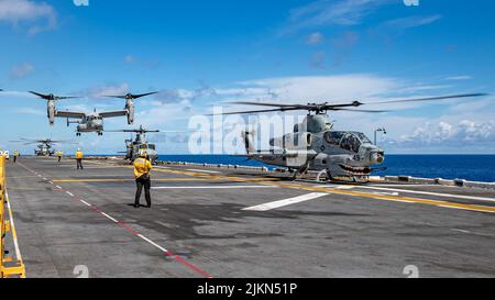 OCÉANO PACÍFICO (29 de julio de 2022) Desde la derecha, un AH-1Z Viper, conectado al Escuadrón de Helicópteros de Ataque de Luz Marina (HMLA) 169, un UH-1Y Huey, unido al HMLA 169, un MV-22B Osprey, unido al Escuadrón de Tiltrotor Medio Marino (VMM) 363, Y un CH-53E, unido al Marine Heavy Helicopter Squadron (HMH) 462, participan en las operaciones de vuelo desde la cubierta de vuelo del buque de asalto anfibio USS Essex de la Marina Wasp (LHD 2) en apoyo de un ejercicio de operaciones anfibias durante Rim of the Pacific (RIMPAC) 2022, julio de 29. Veintiséis naciones, 38 barcos, tres submarinos, más de 170 aviones y 25,00