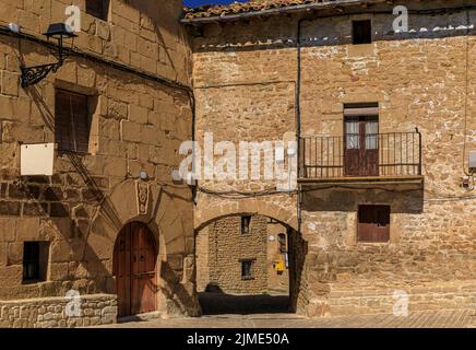Antiguas casas de piedra en la Plaza Mayor de adoquines en un pintoresco pueblo medieval de Ujue en el País Vasco, Navarra, España Foto de stock