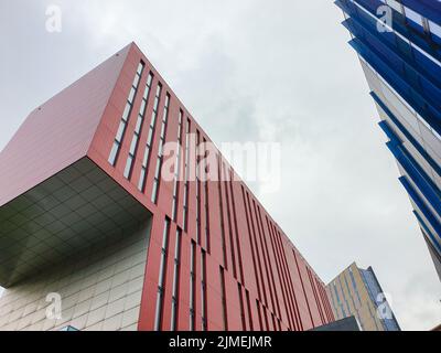 Colores y formas contrastantes en la construcción de fachadas contra el cielo en Manchester, Reino Unido Foto de stock