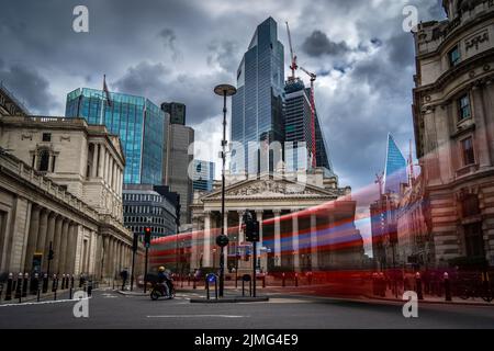 Londres, Reino Unido - Jun 09 2022: Vista de la calle de luz del día del Banco de Inglaterra y la Bolsa Real con un autobús rojo en movimiento borroso delante Foto de stock