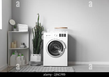 Moderna lavadora y estantería en el interior de la lavandería Fotografía de  stock - Alamy