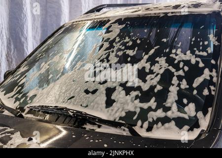 Limpieza del coche con espuma activa. Hombre lavando su coche en auto-lavado  de coches Fotografía de stock - Alamy