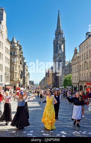 Edimburgo, Escocia, 11 de agosto de 2022 Festival Fringe en la Royal Mile cantantes y bailarines actúan de la obra Beauty and the Beast Foto de stock