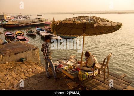 Sacerdote sentado bajo un paraguas enorme en Dashashwamedh Ghat en el río Ganga Ganges, Varanasi, Banaras, Benaras, Kashi, Uttar Pradesh, India Foto de stock