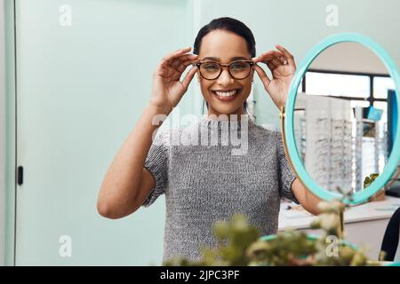 Mujer con un par de gafas modernas, gafas con estilo y nuevas lentes recetadas en un optometrista. Retrato de un cliente que elige, compra y. Foto de stock