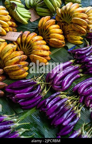 Berenjenas y plátanos sobre hojas de plátano, para su venta en el mercado central de Honiara, en las Islas Salomón. Foto de stock