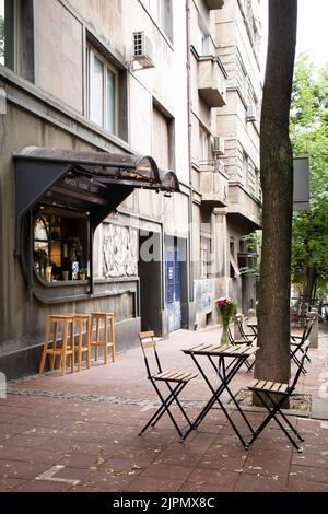 Belgrado-Serbia - 28 de mayo de 2022: Calle café pavimento café bar con sillas y mesas en la acera en Dorcol - área llena de bares y restaurantes a g Foto de stock