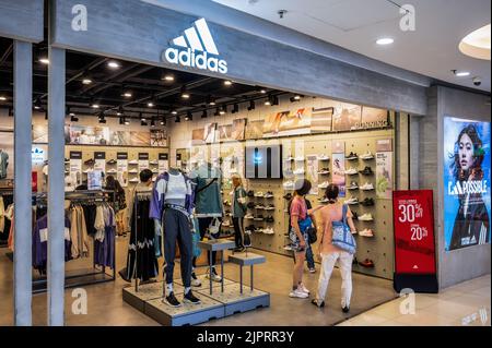 Los compradores ven en la tienda Adidas de la marca alemana de ropa deportiva multinacional en Hong Kong de stock - Alamy