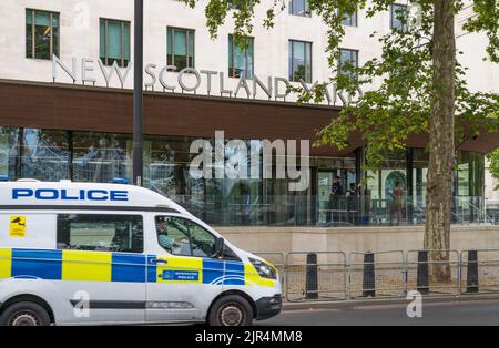 Van de la policía pasando por la sede de la policía metropolitana de New Scotland Yard en Victoria Embankment, Westminster, Londres, Inglaterra, Reino Unido Foto de stock