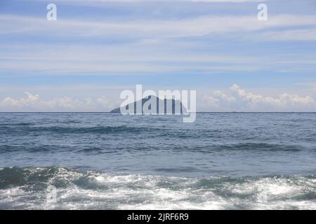 Un día caluroso en la playa y el cielo azul con hermosas nubes en verano, Isla Guishan (Isla Tortuga) en el fondo, Condado de Yilan, Taiwán Foto de stock