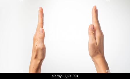 Las manos de las mujeres muestran la distancia con las palmas sobre un fondo blanco. Fotografía de alta calidad Foto de stock