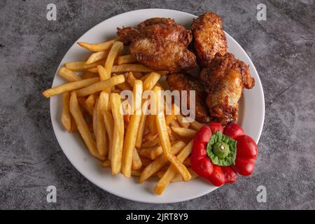 Plato típico de alitas de pollo servido en un patio de comidas Foto de stock