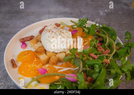 Receta: Huevos escalfados, ensalada de berros, tomates y croutones, vinagre de frambuesa Foto de stock
