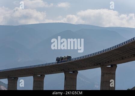 Transportador de coches que conduce a lo largo de un viaducto. Foto de stock