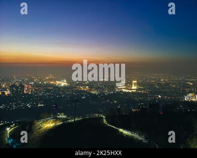 Vista nocturna desde la montaña Kok Tobe hasta la ciudad de Almaty Foto de stock