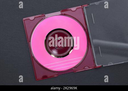Disco compacto, CD dentro de su caja de plástico sobre fondo negro Foto de stock