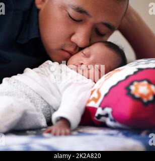 Bajo la mirada amorosa de su padre. Foto de un padre joven que se une con su niña que tiene un paladar hendido. Foto de stock