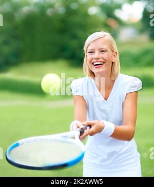 Sólo por diversión. Una joven jugadora de tenis rebotando el balón en su raqueta para divertirse. Foto de stock