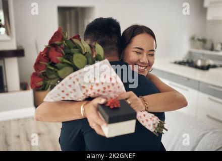 Actos aleatorios de bondad. Foto de un joven sorprendiendo a su esposa con flores en casa. Foto de stock