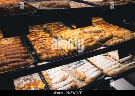 perspectiva vista de primer plano diferentes tipos de pastelería en la panadería de alimentos tienda de la calle ventana Foto de stock