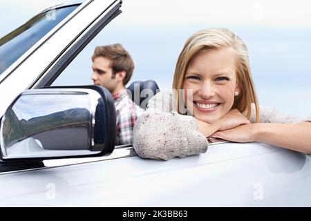 Sentirse relajado y libre. Una joven pareja manejando en un convertible. Foto de stock