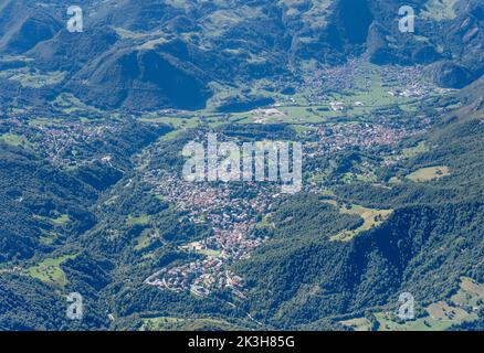 Foto aérea, desde un planeador, de los pueblos montañosos de Barzio y Moggio en el valle de Valsassina, tomada desde el este con luz veraniega brillante, Alpes, Italia Foto de stock