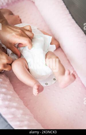 Enfoque selectivo de las manos del hombre Colocar el pañal en un bebé en su cuna Foto de stock