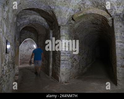 Visitante dentro de los túneles medievales bajo el Castillo de Dover, Kent, Reino Unido. Foto de stock