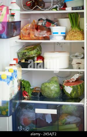 Lleno de alimentos saludables. Vista completa del interior de un frigorífico atascado con comida. Foto de stock