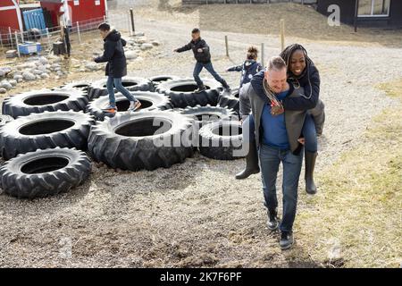Feliz pareja piggybacking cerca de neumáticos de goma en la granja