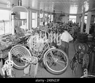 Sandnes 19490415. I BÅS MED 75 000 SYKLER. Firmaet Jonas Øglænd i Sandnes, Rogaland ble grunnlagt i 1868. Øglænd sykkelfabrikk lager 75,000 sykler årlig, halvparten av dem settes sammen su fabrikken, den andre halvparten blir solgt til forhandlere som selv dem sammen eller bruker dem setter som reservedeler. I 1932 lanserte de den beste sykkel - dbs. Fabrikken har ca 400 arbeidere. på jobb i monteringshallen, hvor sykkelen vandrer fra stativ til stativ. Ver hvert stativ blir noen nye deler satt på inntil utstyret er helt komplett. Foto; Sverre A. Børretze / Aktuell / NTB