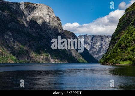 Un paisaje escénico con un lago y grandes montañas bajo un cielo azul en Noruega Foto de stock