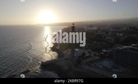 Una foto con aviones no tripulados del faro de Maspalomas cerca de la playa durante la puesta de sol en Gran Canaria, España Foto de stock
