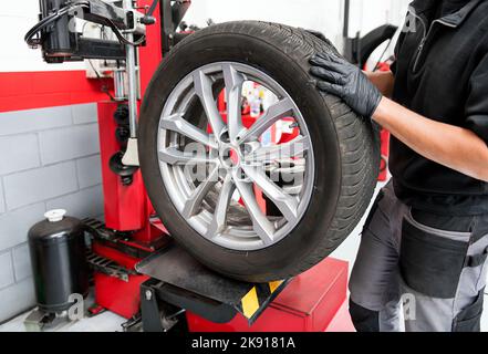 Corte al hombre con uniforme y guantes usando un cuchillo para cortar dulce  pastel fresco en la mesa en la panadería Fotografía de stock - Alamy