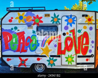 Una colorida caravana con flores y el texto paz y amor en la