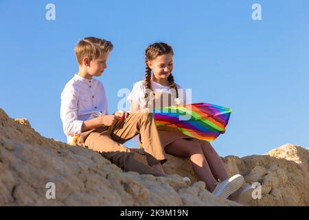 Niño y niña en la primera cita, jugando junto con una cometa. Foto de stock