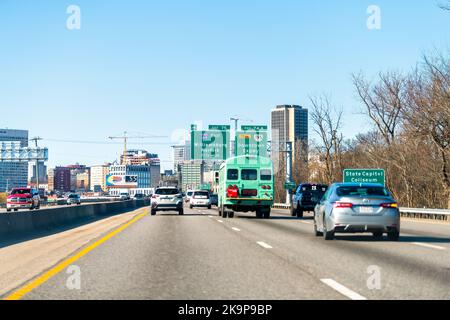 Richmond, EE.UU. - 5 de marzo de 2021: Carretera interestatal 95 de tráfico con coches y Virginia citycape rascacielos con señales Foto de stock