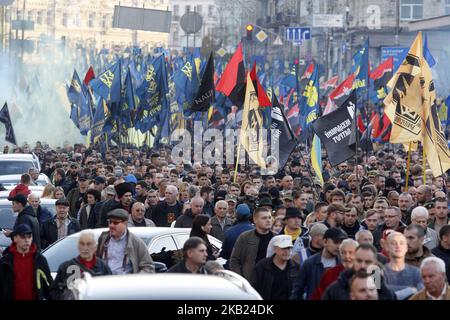 Activistas ucranianos de extrema derecha asisten a una marcha hacia el 76th° aniversario del establecimiento del Ejército insurgente ucraniano (UPA) en el centro de Kiev, Ucrania, el 14 de octubre, 2018.Unas decenas de miles de activistas de extrema derecha y veteranos del conflicto entre las fuerzas gubernamentales y los separatistas respaldados por Rusia en el este de Ucrania caminaron por el centro de Kiev, agitando banderas rojas y negras, símbolo del movimiento nacionalista, Y banderas ucranianas azules y amarillas. Los activistas se reunieron en la capital ucraniana para celebrar el 76th aniversario del establecimiento del insurgente ucraniano Foto de stock