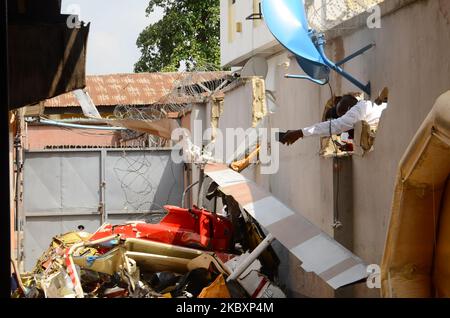 Un hombre toma una fotografía después de un accidente de helicóptero de QUOROM a través de una valla rota, un helicóptero operado por QUOROM Aviation que se estrelló en 16A Salvation Road, Opebi, zona de Ikeja del estado de Lagos alrededor de 12pm, Dos personas murieron en el accidente mientras que otra resultó herida y fue trasladado de urgencia al Hospital Docente de la Universidad Estatal de Lagos, el 28 de agosto de 2020. (Foto de Olukayode Jaiyeola/NurPhoto) Foto de stock