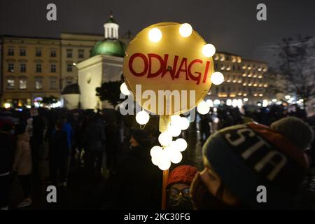 Un activista Pro-Choice sostiene un cartel que dice 'Valor' durante una demonstración en la Plaza del Mercado de Cracovia. Las activistas por los derechos de las mujeres y sus partidarios organizaron el noveno día de protestas en Cracovia y en toda Polonia, oponiéndose a la contención de la pandemia, para expresar su enojo ante la sentencia del Tribunal Supremo polaco, que endureció las ya estrictas leyes sobre el aborto. El 30 de octubre de 2020, en Cracovia, Polonia. (Foto de Artur Widak/NurPhoto) Foto de stock
