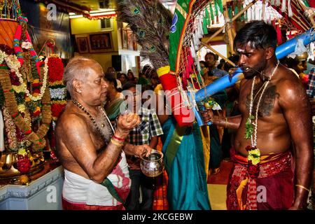 Un sacerdote hindú tamil salpica agua en la cara de un devoto hindú antes de bendecirlo después de que el devoto completara el ritual Kavadi Attam (ritual en el que es tirado mientras baila con ganchos llevados a la espalda como un acto de penitencia) durante el Vinayagar THER Thiruvizha Festival en Ontario, Canadá el 23 de julio de 2006. Los devotos se preparan para la celebración limpiándose a sí mismos a través de la oración, el celibato y el ayuno durante 11 a 25 días antes del festival. Durante este festival religioso varios devotos muestran su devoción haciendo ofrendas y perforando sus cuerpos con ganchos de metal y brochetas. ( Foto de stock