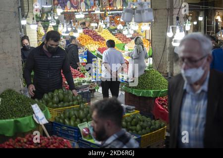 Un hombre iraní observa frutas y verduras mientras hace compras en el bazar tradicional tayrish (mercado), cerca de un santuario sagrado en el norte de Teherán, el primer día del mes santo de Ramadán, dos años después del brote de COVID-19 en Irán, el 3 de abril de 2022. (Foto de Morteza Nikoubazl/NurPhoto) Foto de stock