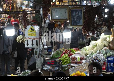 Un hombre iraní observa verduras mientras hace compras en el bazar tradicional tayrish (mercado), cerca de un santuario sagrado en el norte de Teherán, al final del primer día del mes santo de Ramadán, dos años después del brote de COVID-19 en Irán, el 3 de abril de 2022. (Foto de Morteza Nikoubazl/NurPhoto) Foto de stock