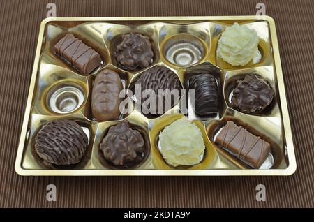 bombones en una caja, primer plano, aislado sobre fondo marrón, vista superior Foto de stock